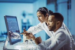 Male and Female Student Working in The Laboratory, Using Touch Screen Computer